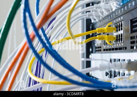 Yellow Ethernet patch cables connecting Netgate 7100 firewall appliance running pfsense to local area network Stock Photo