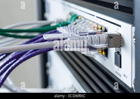 SFP+ 10 Gbps Direct Attach Cable plugged into 10GbE SFP+ port on a UniFi Switch Pro 24 PoE Stock Photo
