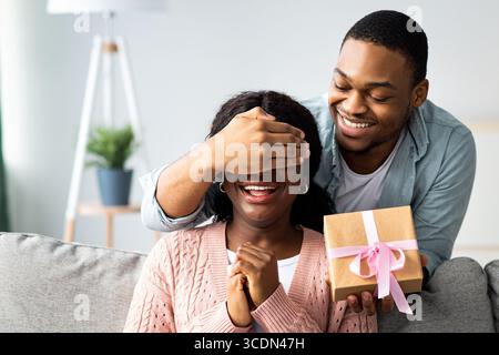 Cheerful black man making surprise for his wife Stock Photo