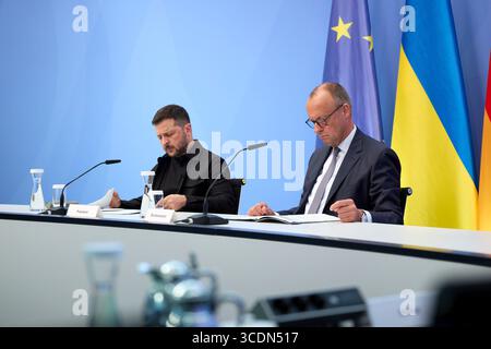 Berlin, Germany. 13th Aug, 2025. Ukrainian President Volodymyr Zelenskyy, left, and German Chancellor Friedrich Merz, right, listen during a virtual summit meeting at the Chancellery, August 13, 2025 in Berlin, Germany. The two leaders hosted a virtual summit with European leaders and U.S President Donald Trump to discuss the upcoming US-Russian Summit. Credit: Pool Photo/Ukrainian Presidential Press Office/Alamy Live News Stock Photo