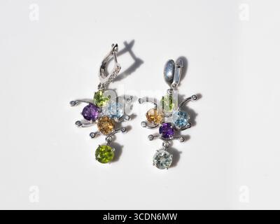 Elegant sterling silver drop earrings showcase a cluster of brilliant amethyst, citrine, and blue topaz gemstones, perfect for fashion, luxury, gift o Stock Photo