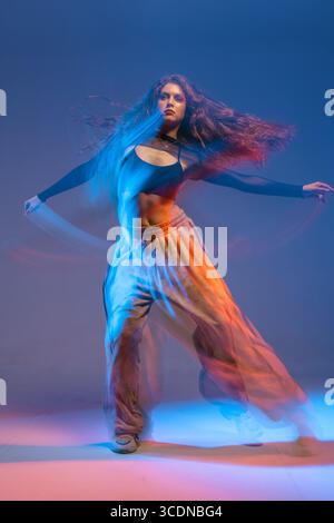 Confident jazz funk dancer in dynamic motion with colorful lighting, capturing the energy and attitude of modern dance. Stock Photo