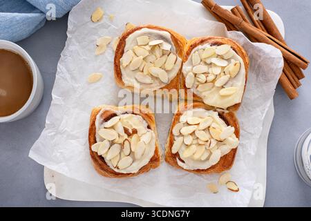 Cinnamon rolls topped with cream cheese frosting and sliced almonds, freshly baked and ready to eat Stock Photo