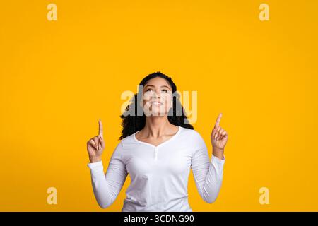 Look There. Black Female Pointing Up At Copy Space With Two Fingers Stock Photo