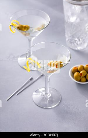 Lemon martini cocktail garnished with stuffed olives and lemon twist Stock Photo