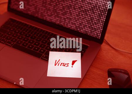 Virus, warning sign, laptop infected. Virus, warning sign, laptop infected. Binary code, bits and bytes. Note, message, cyber attack, threat, network security, hacked, computer crime. technology computer virus B97A8628 Stock Photo