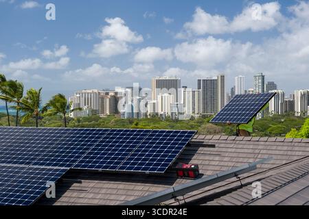 Man carrying photovoltaic panel on residential rooftop during installation of Solar PV system, Honolulu, Oahu, Hawaii, USA Stock Photo
