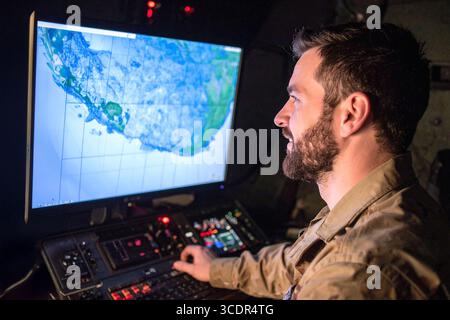 One of the series of photos : Military Analyst looking at large map screens with Stock Photo