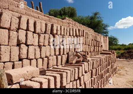 Traditional manufacture of adobe bricks drying under the sun in an open-air factory in Fiambala, Catamarca, Argentina. building materials from earth Stock Photo