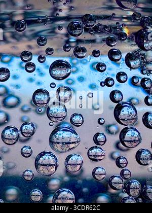 Sparkling bubbles, pearl spheres of bubbly champagne rising and clustering catching the light, like tiny floating effervescent droplets Stock Photo