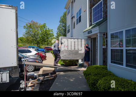 Movers unloading mattress from the back of a moving truck, Burlington, Massachusetts, USA Stock Photo
