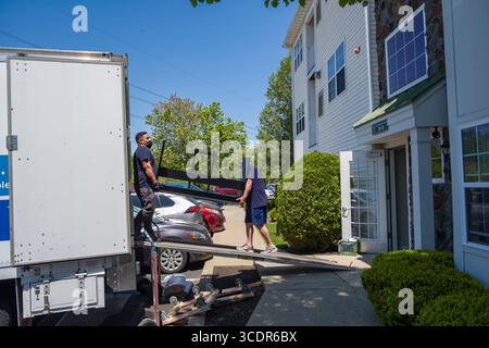 Movers unloading household items from the back of a moving truck, Burlington, Massachusetts, USA Stock Photo