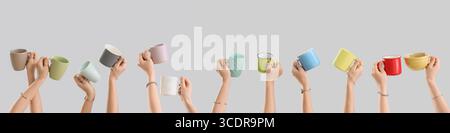Many hands holding ceramic cups on grey background Stock Photo