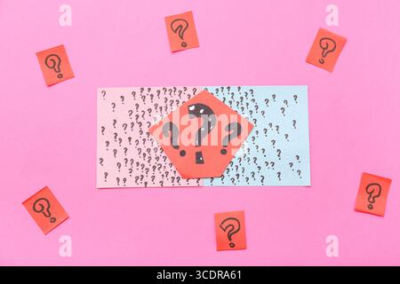 Paper quiz card with question marks on pink background Stock Photo