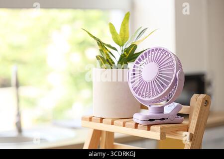 Lilac mini fan on shelf in kitchen, closeup Stock Photo