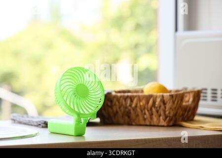 Green mini fan on table in kitchen, closeup Stock Photo