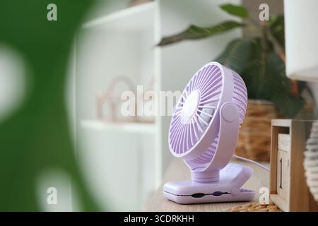 Lilac mini fan on shelf in room, closeup Stock Photo