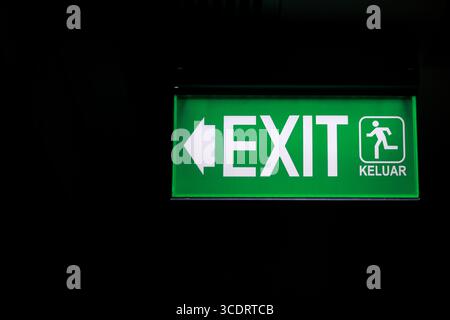 Emergency exit sign with a striking green color. Stock Photo