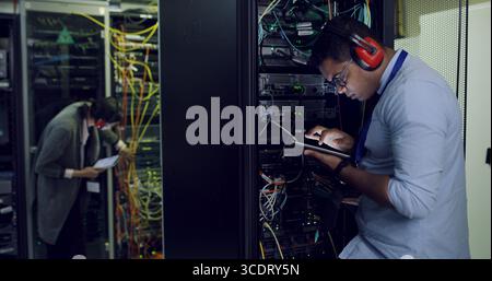 Infrastructure, maintenance and tablet with IT professional in server room for cybersecurity support. App, database and inspection with people in Stock Photo