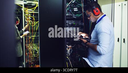 Database, inspection and tablet with IT professional in server room for cybersecurity support. App, infrastructure and maintenance with people in Stock Photo