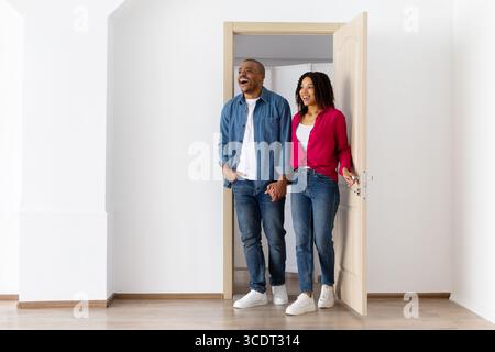 Excited young African American couple entering bright new home after relocation Stock Photo