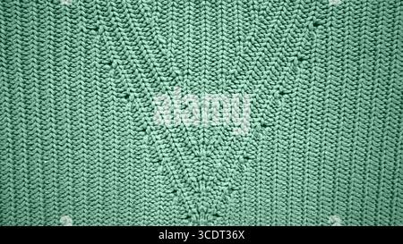 Background filled with knitting texture. With ornament. Mint green color. Vertical stripes. The stripes form triangles in the middle of the background Stock Photo
