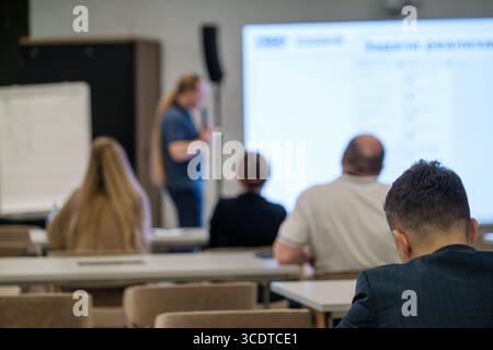 People engaged in a presentation at a business seminar emphasizing teamwork and collaboration Stock Photo