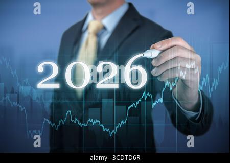 Man in suit with digital pen pointing at virtual screen with 2026 number. Represents stock market investment, financial analysis, and strategy Stock Photo