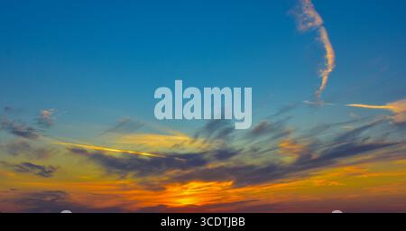 Abstract sky with pearl blue tones and soft clouds fading from orange to grey in a smooth gradient. Stock Photo
