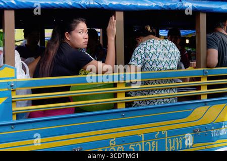 A distressed or offended looking Thai woman looking out of a songthaew, a local public transport vehicle in Phuket, Thailand Stock Photo