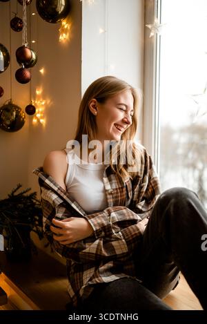 Woman Enjoying Cozy Winter Moments by the Window Stock Photo
