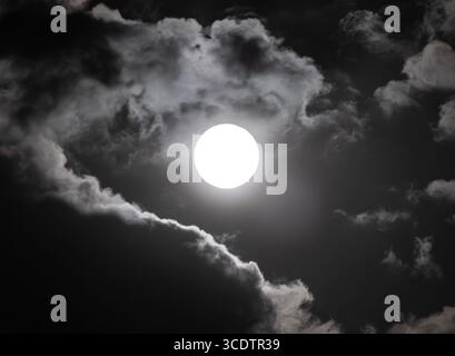 The full moon illuminating the passing clouds over Worcestershire, England. Stock Photo