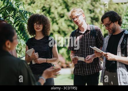 Group of students and professor actively engaged in an outdoor educational discussion Stock Photo