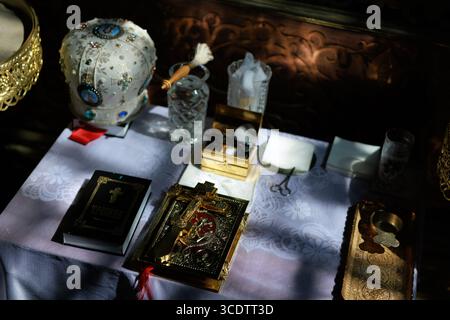 Close-up of a golden Orthodox cross on ornate Gospel book, placed on the altar during a church service. The intricate details, warm light and sacred a Stock Photo