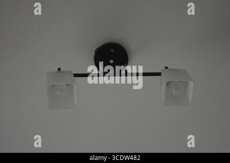 Things, interior items, beautiful chandelier with white matte shades and white diode lamps hangs on the ceiling of room in city Dnipro, Ukraine. Stock Photo