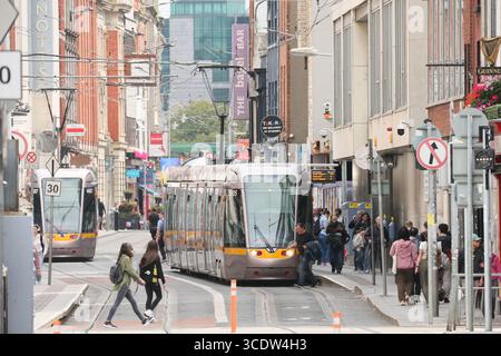 Dublin, Ireland  -  25th July 2025 - The Jervis Street red line Luas tram stop as two Luas trams pass through on a busy afternoon Stock Photo