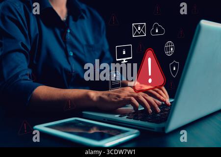 Businesswoman receives cyber security warning alert on smartphone and computer, data vulnerability, compromised information illegal, concept of digita Stock Photo