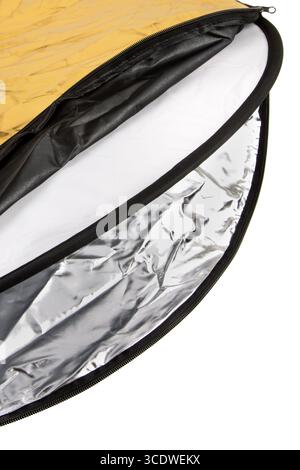 A close-up of a zippered 5-in-1 photography reflector showing gold and silver surfaces. Stock Photo
