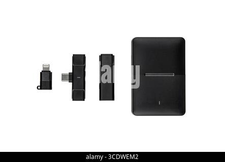 A wireless microphone kit with charging case and adapters, isolated on white. Stock Photo