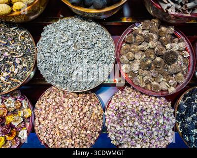 Assorted bowls of dried herbs spices &  flowers at  spice souk, market Dubai, Deira creek, showcasing various textures and colors, UAE Stock Photo