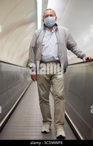 Middle aged man on moving walkway Stock Photo