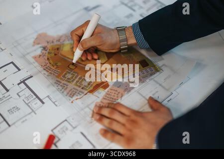 Professional working on detailed architectural and urban planning map using marker Stock Photo