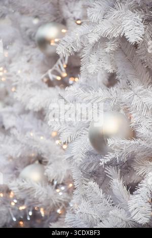 White decorations on artificial white Christmas tree with copy space Stock Photo