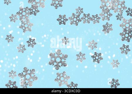 Silver snowflakes falling with snow on light blue background Stock Photo