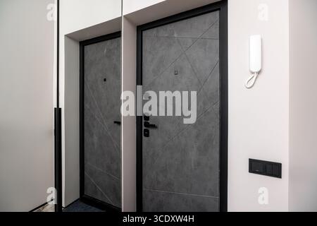 Two doors with a black frame and a grey color. The doors are next to each other. The doors are made of metal Stock Photo