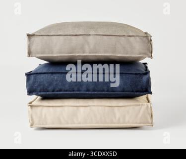 Stack of three cushions forming a relaxing pile on white background Stock Photo