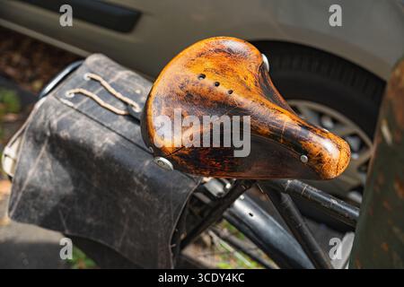 Close-up of a worn leather bicycle saddle and rear-mounted bag Stock Photo