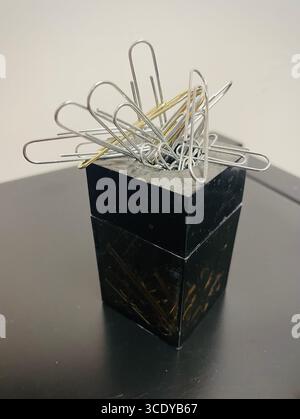 Close-up of a metallic paperclip holder filled with paper clips on a desk, United States, 2025 Stock Photo