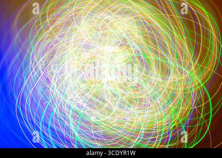 Dynamic and colorful light trails create a captivating abstract pattern. this lively composition features swirling lines in a spectrum of colors, evok Stock Photo