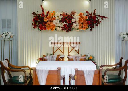 Elegant "akad" wedding decoration featuring red, orange, and white flowers as a central focus. Stock Photo